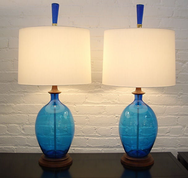 Pair of glass lamps with wood fittings made by Blenko Glass Company. Glass finials. Custom shades.