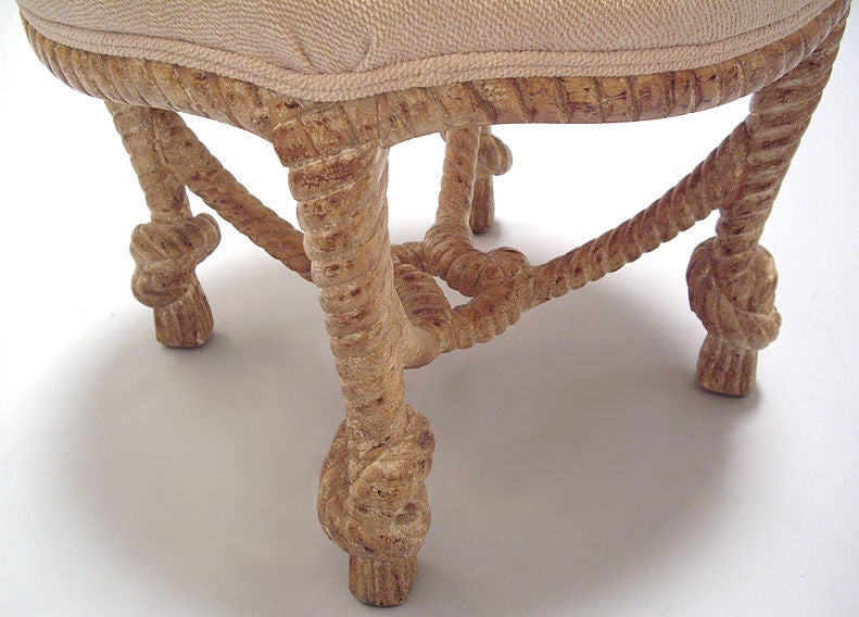 Carved wood and upholstered ottoman.
