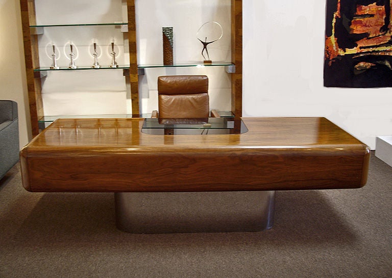 Walnut and stainless steel desk from Stow Davis. Designed by M.F. Harty. Features inset smoked glass writing area, drawers that lock including a file drawer. Top quality materials and construction. The ultimate 1970s executive desk.