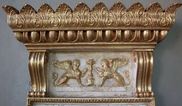 A fine example of this period, the dramatic cornice of outscrolled anthemion decoration above egg-and-dart carving; over a frieze adorned with facing seated griffins flanked by scrolling volutes; the long rectangular plate within an ogee frame