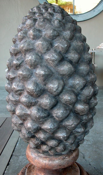 An unusual and massive pair of French concrete pinecone-form finials; each robust pinecone finial with dramatically textured surface; mounted on later russet-colored painted turned wooden bases (intended for indoor use)
