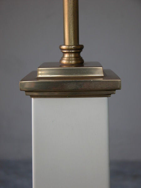 A stylish pair of American mid-century ivory-painted tole and brass obelisk-form lamps; labeled "Warren Kessler, New York"; each tall, obelisk form with graduated body above a square base; adorned with brass fittings