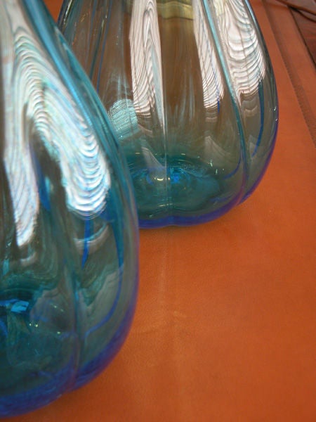 A shapely pair of Italian 1960's aqua-colored lobed art glass bottle vases with clear stoppers; each with dramatically pointed clear glass stopper fitted into a bottle-form vase with lobed sides