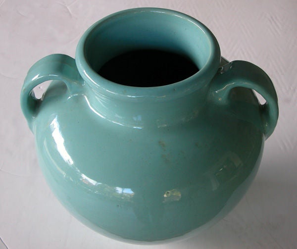 A large-scaled American pottery aqua-glazed double-handled urn; the flaring neck above an ovoid body flanked by loop handles.
