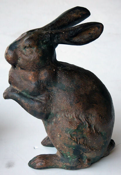 A delightful and well-patinated pair of Japanese iron rabbits; each with expressive gaze and long ears; one reclining while the other is perched on its hind legs