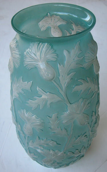 A tall American 1940's sculptured art glass vase of frosted aqua glass with raised meandering thistle branches; labeled 
