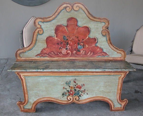 A fanciful Venetian Baroque style pine polychromed high back bench; with high cartouche-shaped back centering an over-scaled coral painted shell motif; above a faux marble hinged seat over a solid apron with scalloped border; in colors of coral,