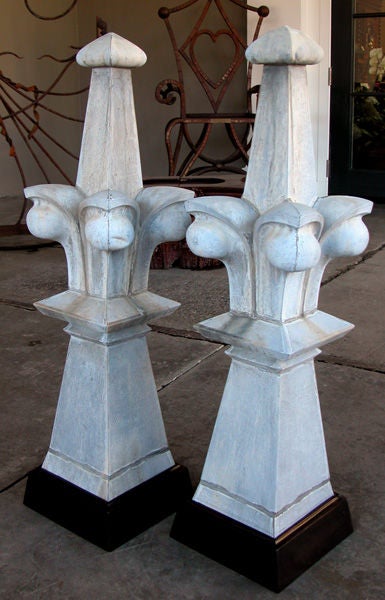A large-scaled pair of French gothic style zinc roof finials; each with graduated spire surrounded by protruding crocket ornamentation; raised on a flared base over a later ebonized wooden plinth