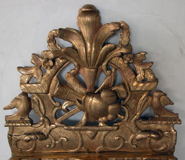 A well-carved French Napoleon III giltwood mirror with exuberant crest; the arching pierced crest surmounted by protruding feathers above a plumed helmet all flanked by opposing birds; the rectangular frame adorned with lively scrollwork on diaper