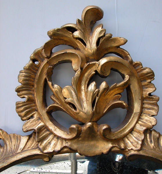 Hand-Carved An Elegantly Carved French Louis XV Style Rococo Giltwood Oval Mirror For Sale