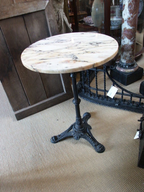 Charming small marble top pub table with painted black iron base and round marble top.