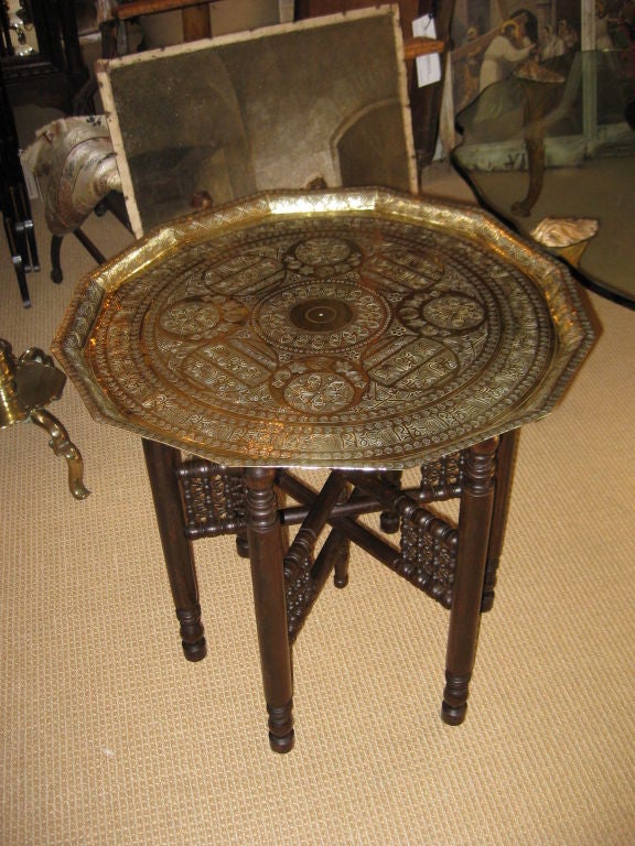 Great looking middle eastern hammered brass tray with ornate turned spindle base that folds up