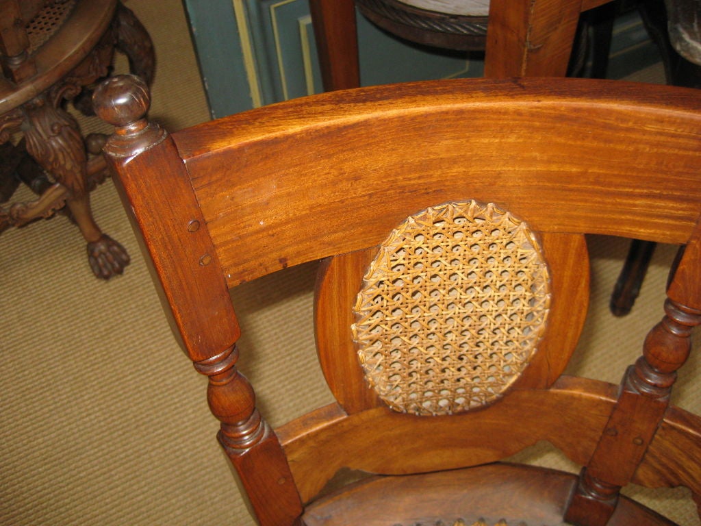 Padouk wood burgermeister chair from the late 18th C  the curved wood back and three caned roundels above a circular caned seat on block supports, the six legs are joined to eachother  by circular stretchers. 