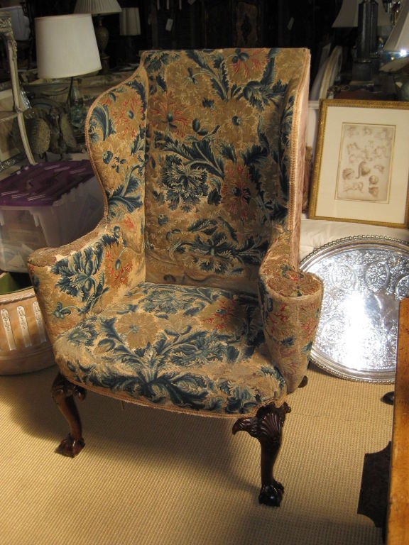 Stunning wing back armchair with rectangular back and padded sides continuing to outscolled arms with a bowfront cushioned seat raised on shell and acanthus carved cabriole legs flanked by eagles heads and ending in claw and ball feet.