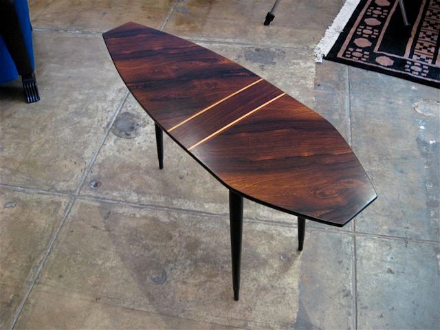 Swedish mid-century coffee table in rosewood, in an angular surfboard shape on tapering ebonized legs.

The price listed is the FINAL NET price, which reflects a 50% reduction-extended through the Svenska Mobler closing sale. Call us directly at