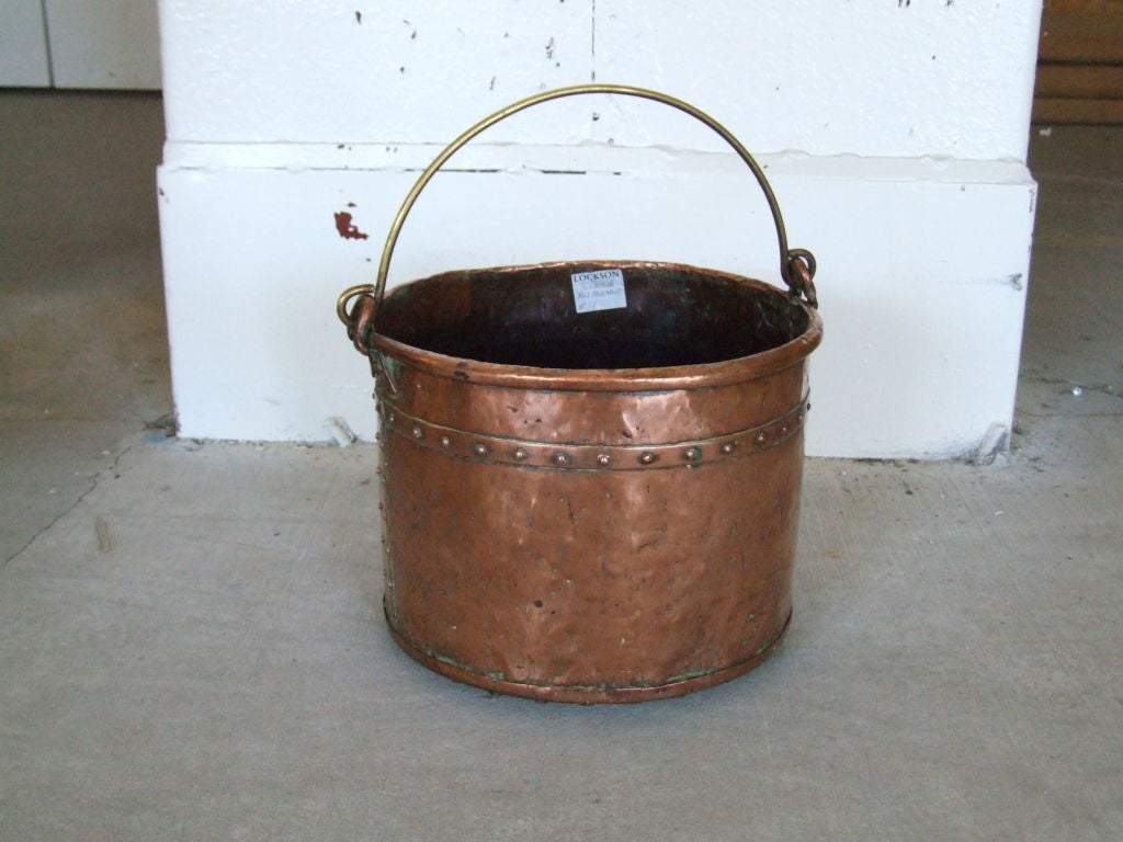 An early 19th c. English bucket of copper having rolled rim, brass carrying handle and hand-riveted seams, with nicely beaten surface.

firewood, kindling, log holder