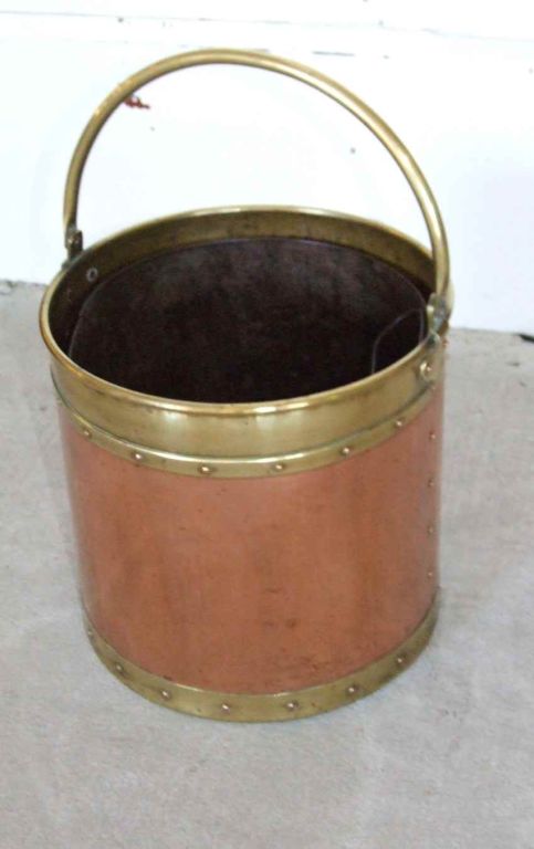 English 19th century brass rimmed copper apple kettle with hollow brass carrying handle, brass rivets and removable liner.  Decorative and useful next to a fireplace for kindling and papers.