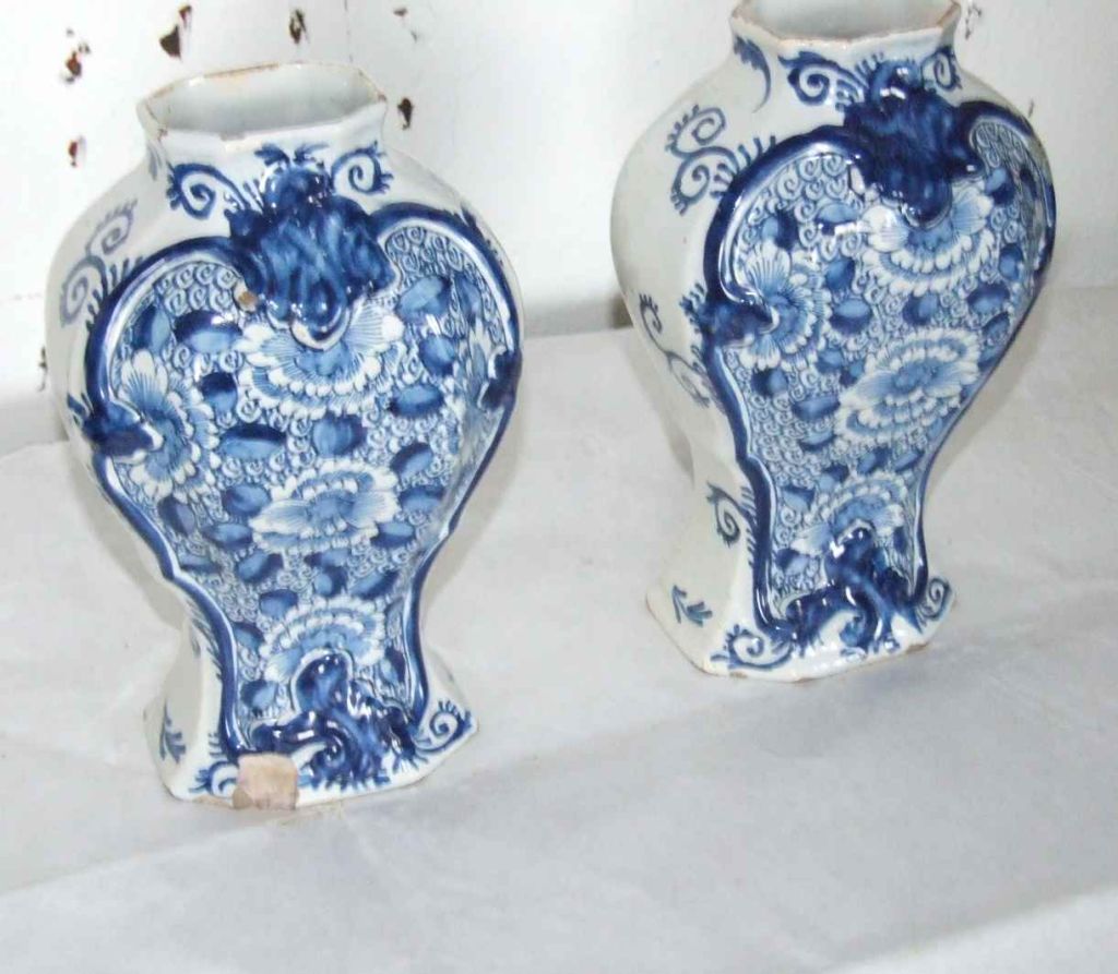 Pair of 18th century Dutch delft vases with floral pattern within a rococo border, the reverse with single flower with entwined vine decoration