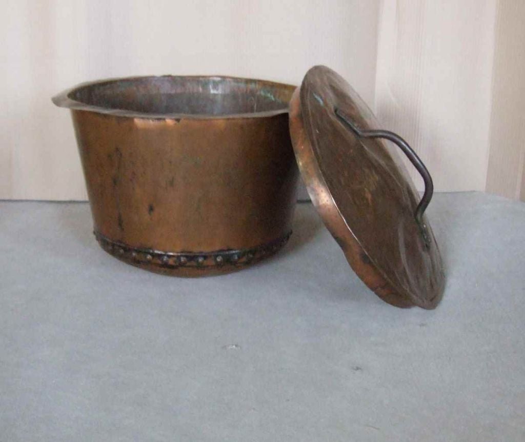 An early 19th century English apple kettle or boiler, of kettle with hand rivetted seams.  Retaining rare original lid, having iron carrying handle.

firewood, kindling, log holder