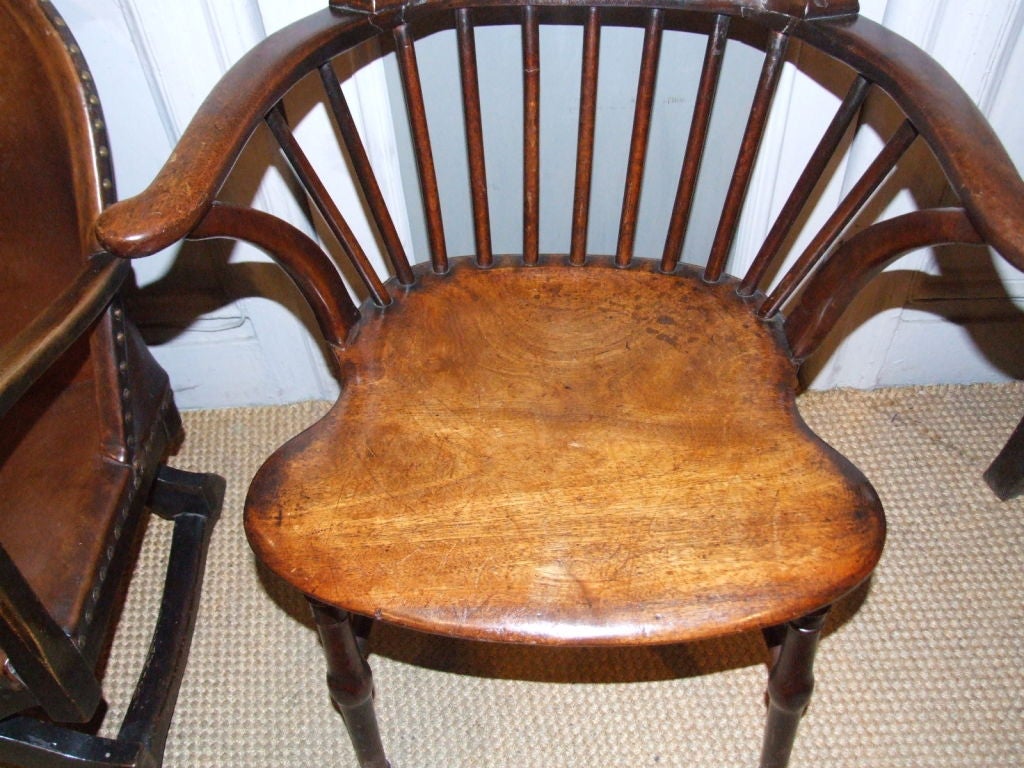 18th century English mahogany comb-back windsor having shaped crest over spindle back over deeply saddled seat made from one piece of figured mahogany, finely turned legs, joined by H- stretcher Note: this windsor is rare not only for being made