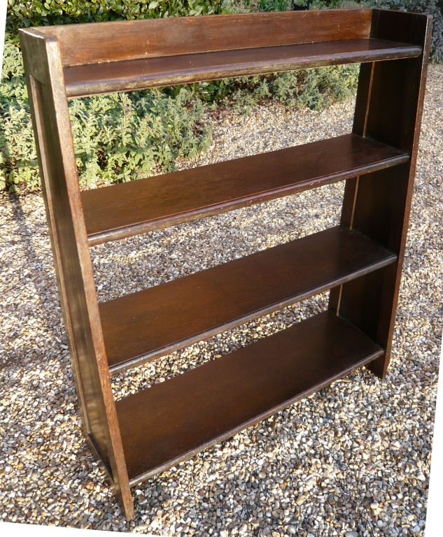 A 1930's English art deco bookcase in oak with four shelves on angled end supports