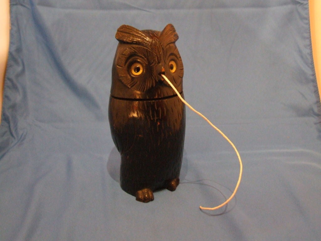 A 19th century English carved owl with glass eyes, made to hold string.