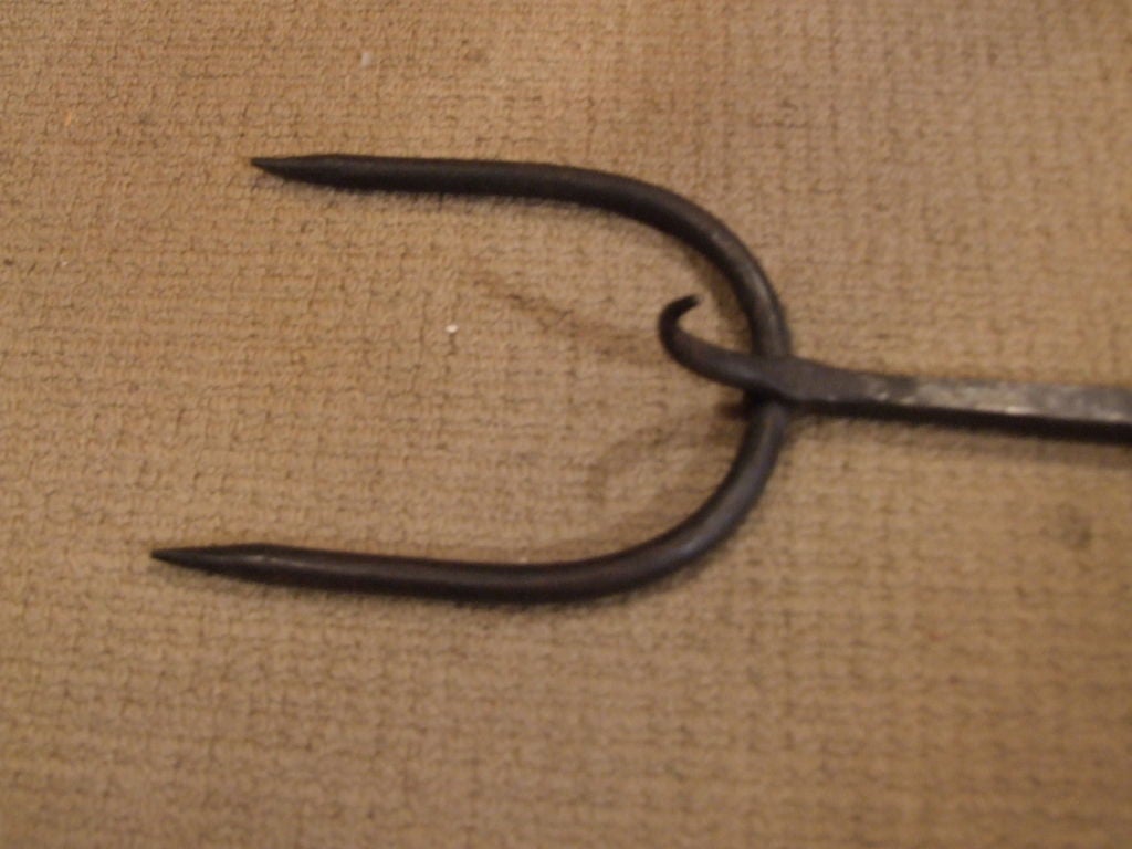 An 18th C blacksmith-made fire fork with two prongs and a third support prong, twist decoration to shaft and handle.
