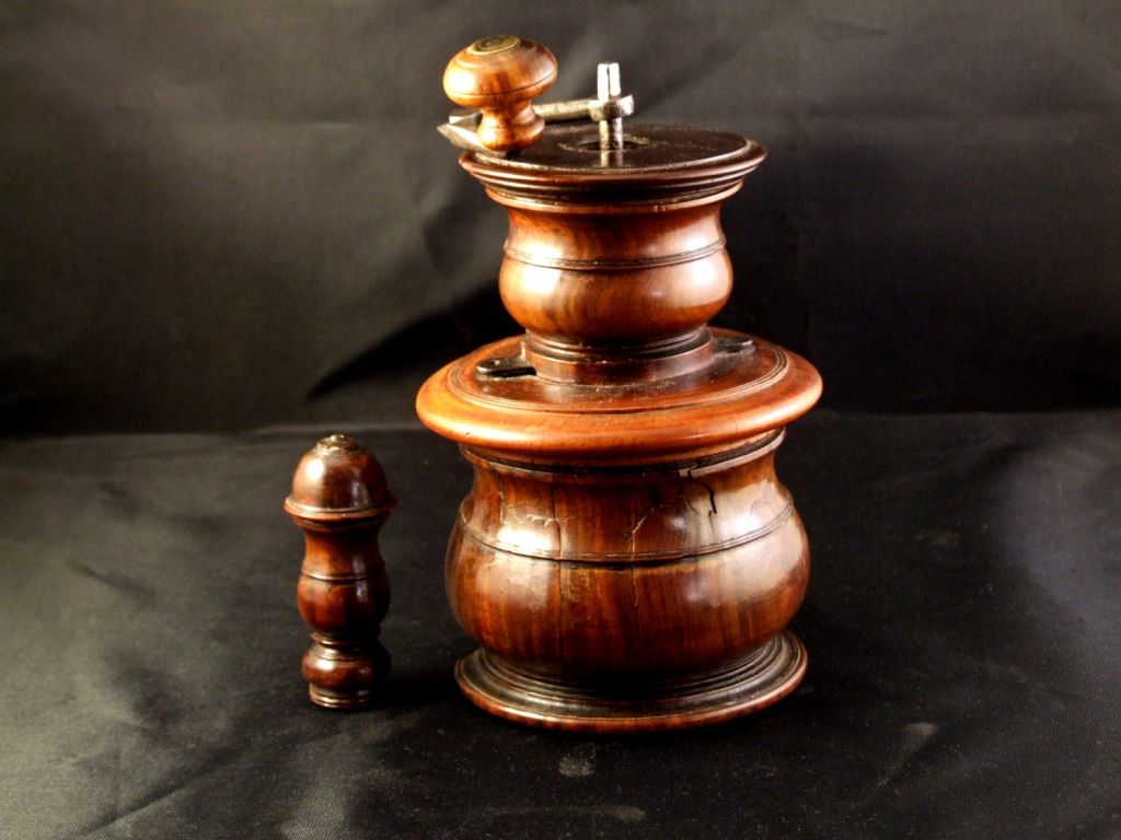 English or Dutch 17th Century lignum vitae and steel coffee grinder made in multiple sections, the removable finial concealing the square shaft, the section below with removable lid for placing the beans, the base hollowed to collect the grounds,