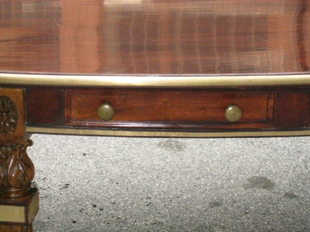 Unusual brass-inlaid, hand-carved oval library table on louis XVI-style legs with eight drawers