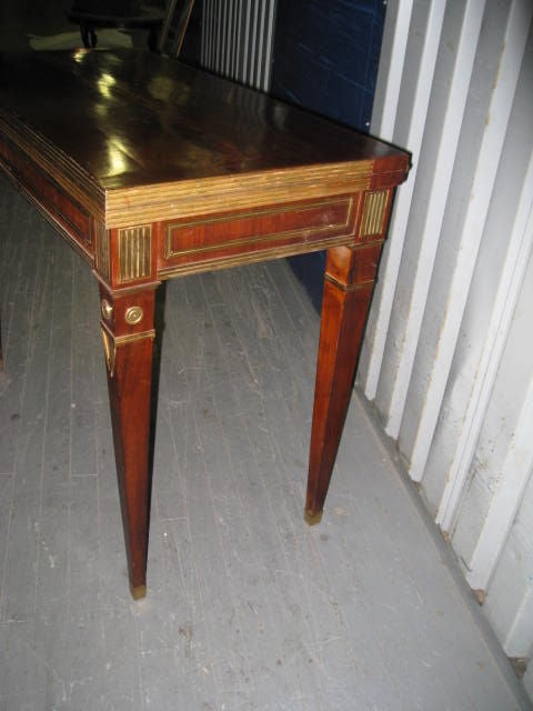 Brass-inlaid mahogany card or gaming table in the neoclassic manner, featuring beautifully tapered legs.