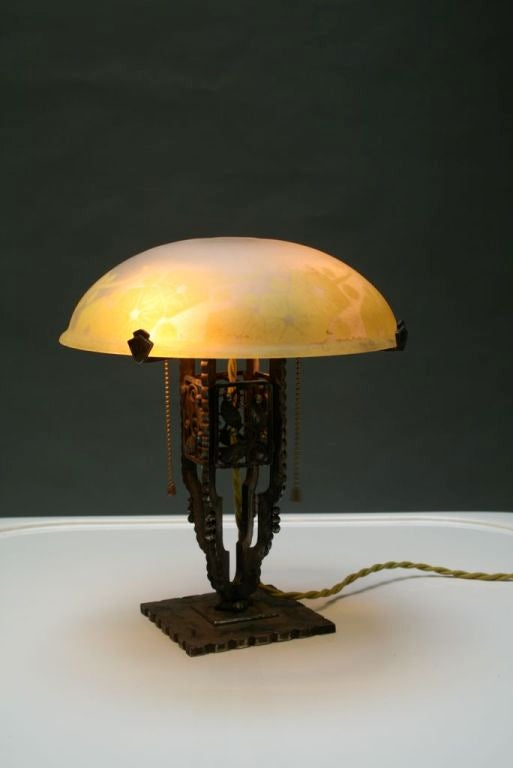 Hand wrought iron base rendered in the 20's French, Art Deco style (a la Edgar Brandt). White- green cameo shade with 