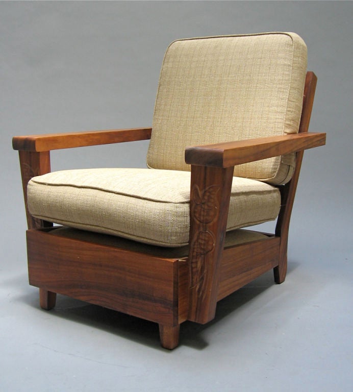 These solid koa wood club chairs were made by Hawaiian convicts (prison rehabilitation program) during the 1940's. Koa wood has not been permitted to be cut for several decades. Arms of the seating feature a hand carved tropical foliage motif. This