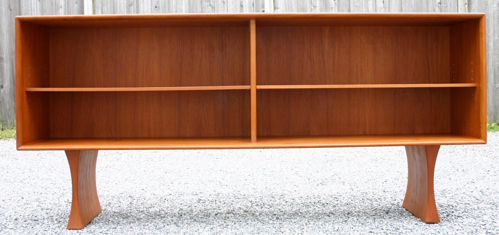 Long teak cabinet with adjustable shelves; sliding glass enclosure. Cabinet is 20