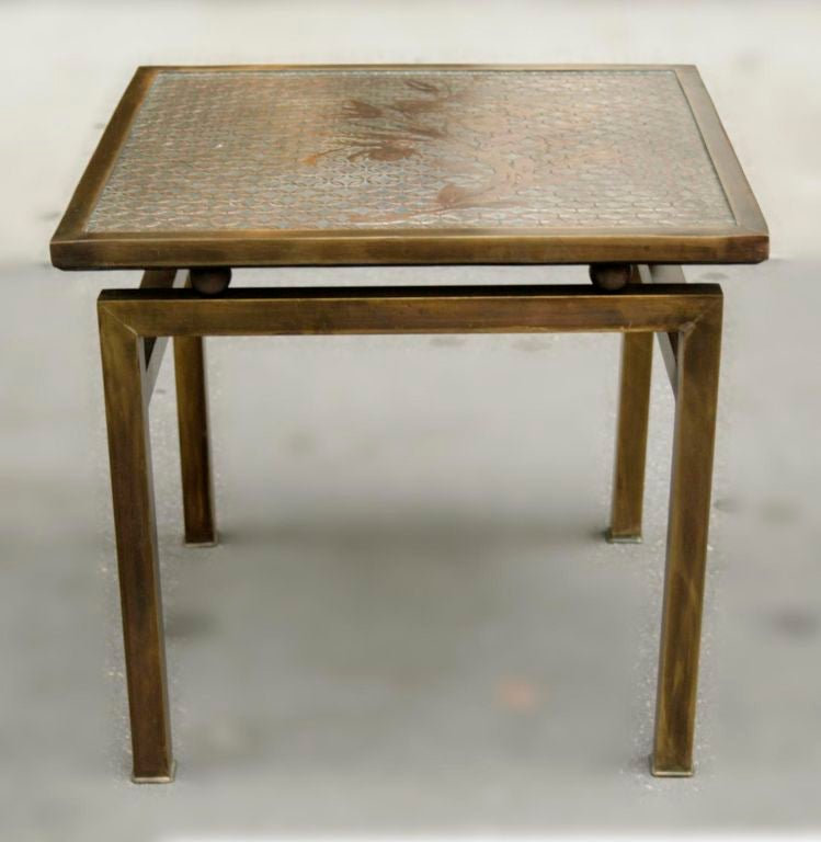 A delicate and elegant occasional low table in the LaVerne’s cherished patinated bronze technique. The table’s surface has a lovely stylized floral motif.