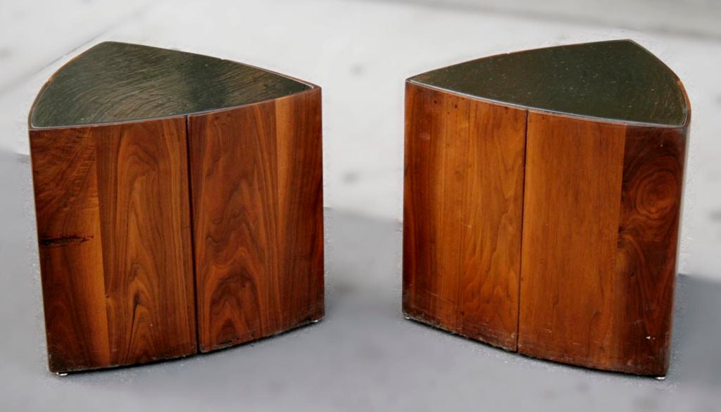 A Pair of triangular walnut side tables by Phillip Lloyd Powell, c. 1955.  Each have an inset heavily lacquered slate top, the sides have vertically positioned boards that meet seamlessly at the corners but leave a slender gap at their juncture on