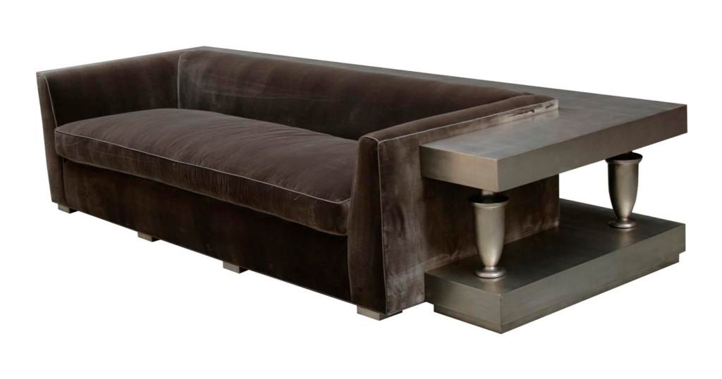 A silver leaf surround sofa by James Mont, c. 1950. A brown, silk velvet sofa surrounded by a silver leaf frame with five urn-shaped balustrades. The upholstered sofa is rectilinear with straight arms; the balustrades are turned and support an upper
