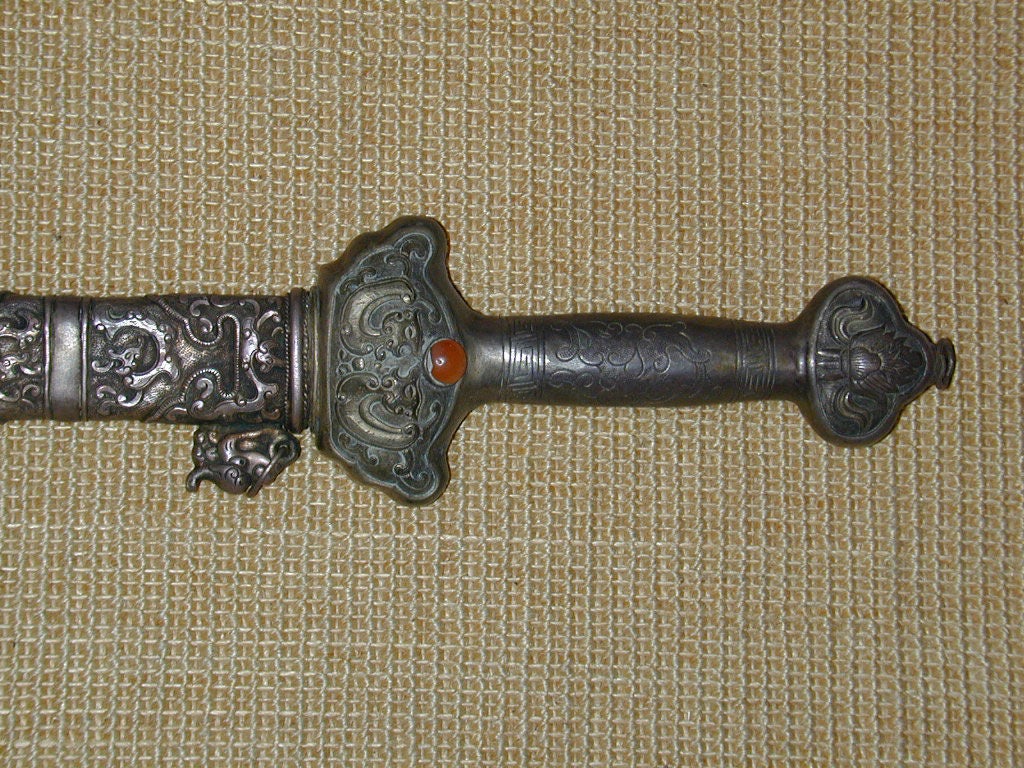Tibetan silvered metal ceremonial sword with repousse designs and inlaid hard stone decorations.