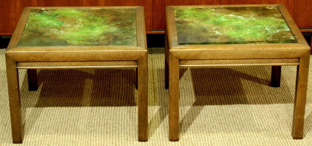 A pair of occasional tables with green and gold reverse painted glass tops with glass inset and flush to the top of the wood table frames by Henredon. U.S.A., circa 1960.