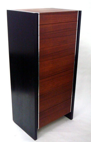 A tall lingerie chest executed in walnut veneer and ebonized oak case, having four pairs of graduated size drawers with recessed hidden pulls by Kip Stewart for John Stuart. American, circa 1960.