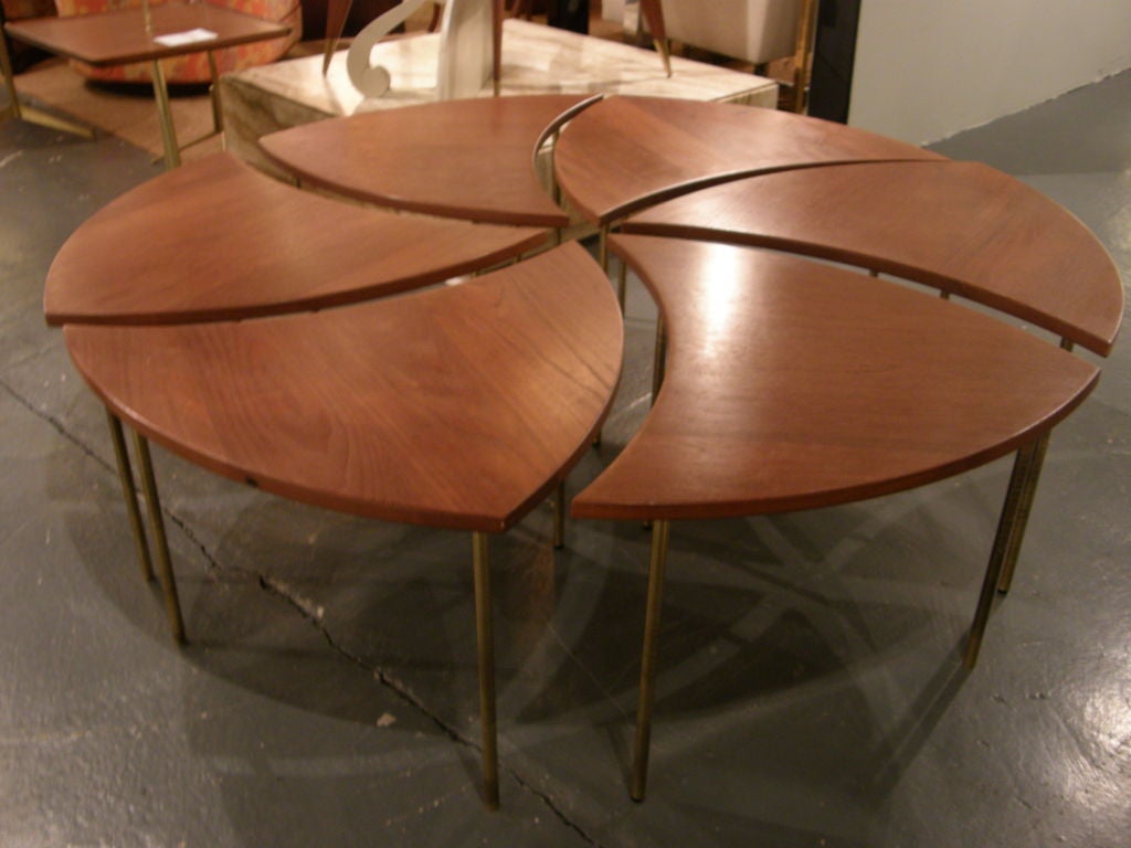A cocktail stacking nest of tables comprised of six sections, each with teak tops and three brass legs, mod. no. 523, by Peter Hvidt, 1916-1986 and imported by John Stuart, Inc. Danish, circa 1952.