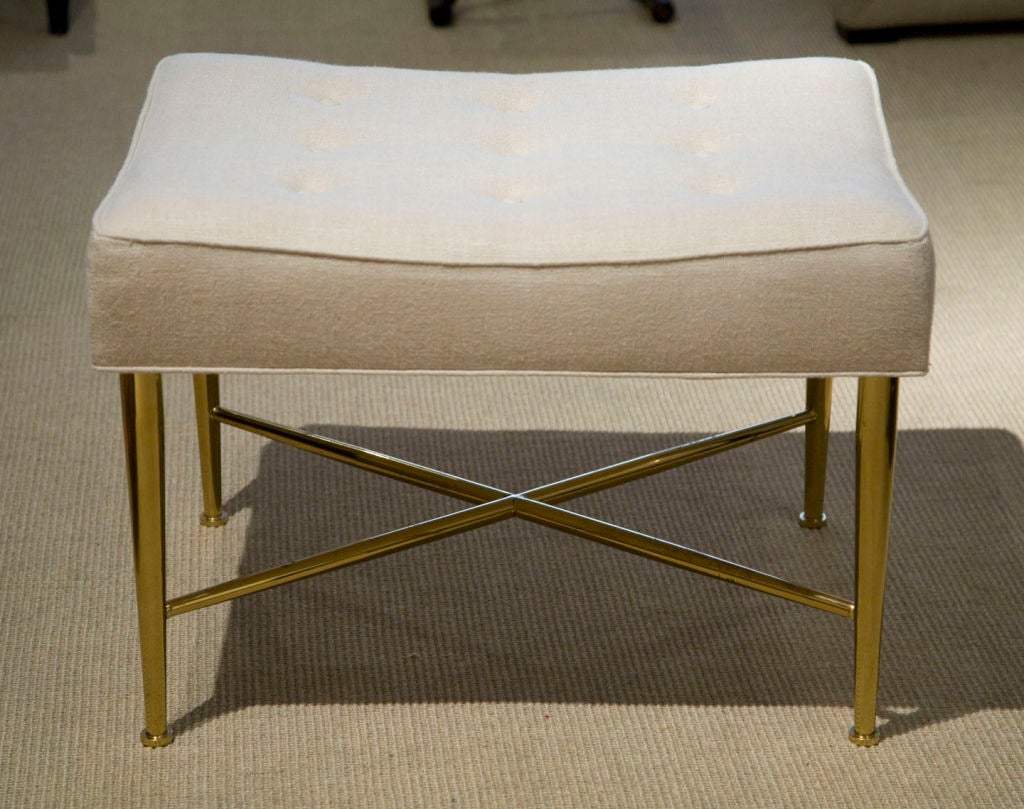 A rectangular button tufted upholstered bench raised on a polished brass X-stretcher base with tapered legs, terminating in a coin foot by Edward Wormley for Dunbar. American, circa 1950.