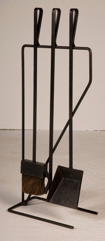 A set of three wrought iron fireplace tools and freestanding rack after George Nelson. American, circa 1950.