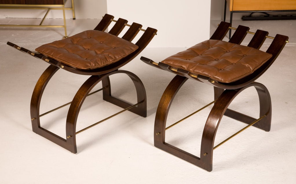 A pair of 'knights benches' in steam bent mahogany with brass fittings and loose leather cushions by Harvey Probber. U.S.A., circa 1950.