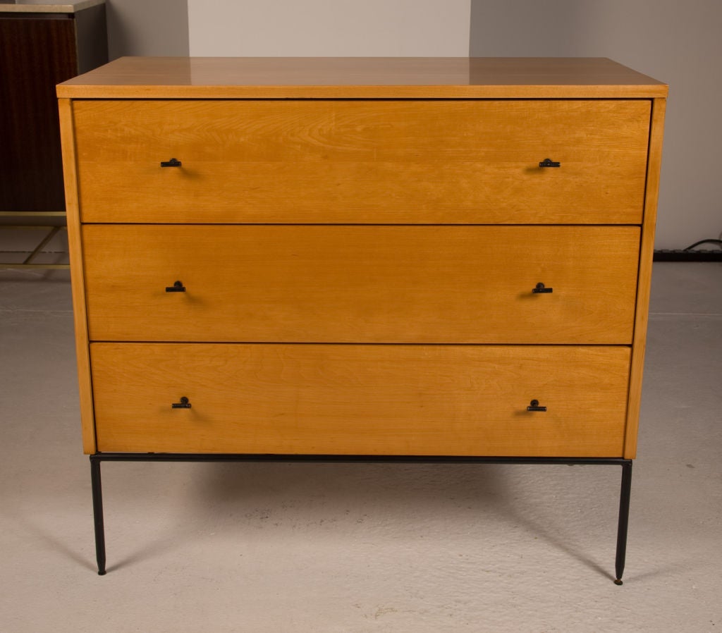 A scarce pair of Modernist bachelor's chests with T-pull hardware raised on solid round wrought iron bases from the 'Planner Group' collection by Paul McCobb for Winchendon Furniture. U.S.A., circa 1950.