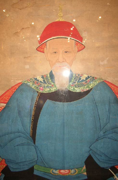 Fine brush painting of a Qing Dynasty 1644-1911 nobleman wearing formal imperial court robe and hat, sitting on a chair covered with fabric, benevolent facial expression, exquisite detail, beautiful colors, museum conservation framed. View our