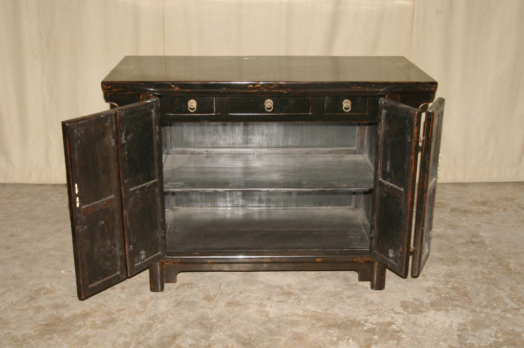 A refined and elegant black lacquer sideboard with hand painted gold gilt motif on the pair of bifold doors, brass fitting. Visit our website at: www.greenwichorientalantiques.com for additional sideboard selections.