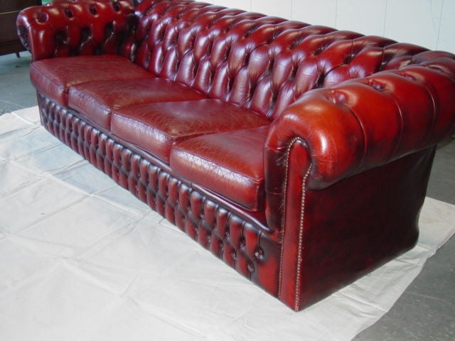 Beautiful  red/brown vintage leather English Chesterfield Settee.Four large cushions,tufted back rest and sides,moves on casters easily.
