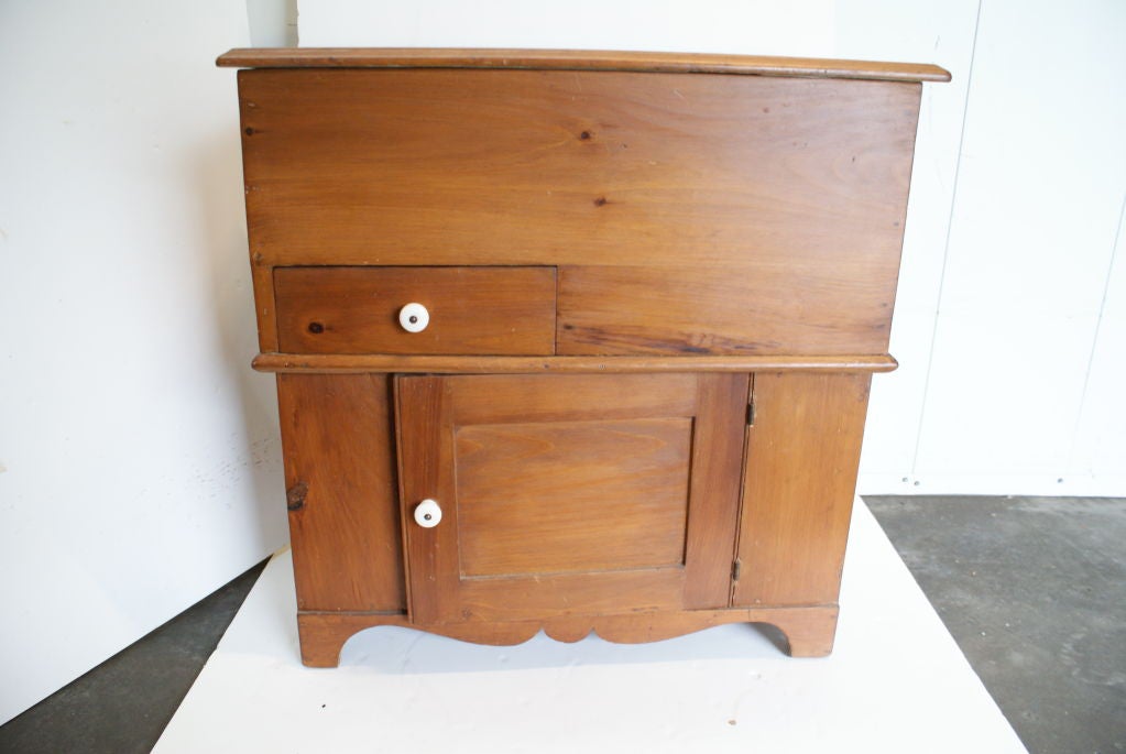 Late 19thc New England Pine Dry Sink.The top opens to  a step shelf interior.Front showing one small opening drawer,and one  door on the bottom,the inside has good storage space.The pulls are original,and made of porcelain. Great for a bar or end
