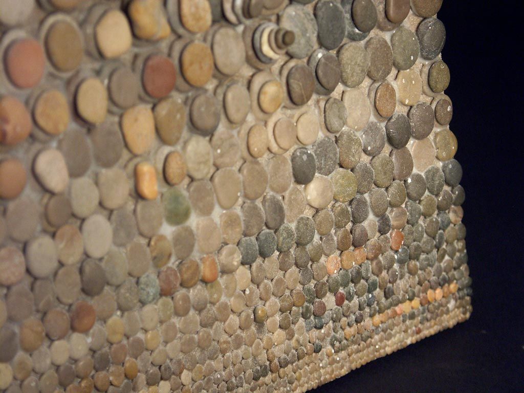 Dramatic and obsessive assemblage of stones by Mary Bauermeister. Thousands of ocean hewn stones are arranged in descending order form stacks of larger rocks along the top edge, to a single layer of nearly microscopic specimens at the bottom.