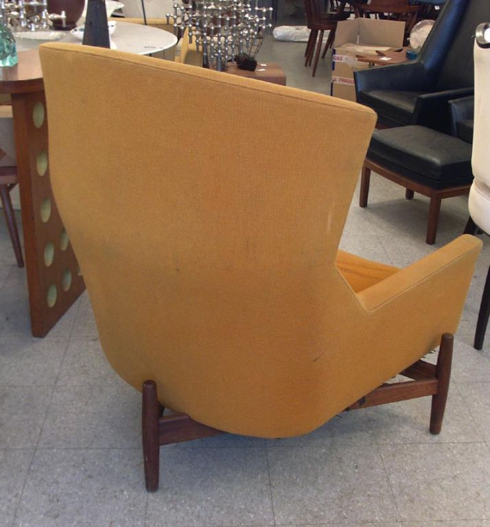 By far Risom's most ambitious design, this massive lounge has an incredible presence, matched only by its comfort. Set on its wide teak tripod base, the chair features a high curved backrest, generous lowback cushion, and wide set armrests. The